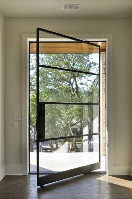 Custom steel and iron pivot door entry for a modern Austin home